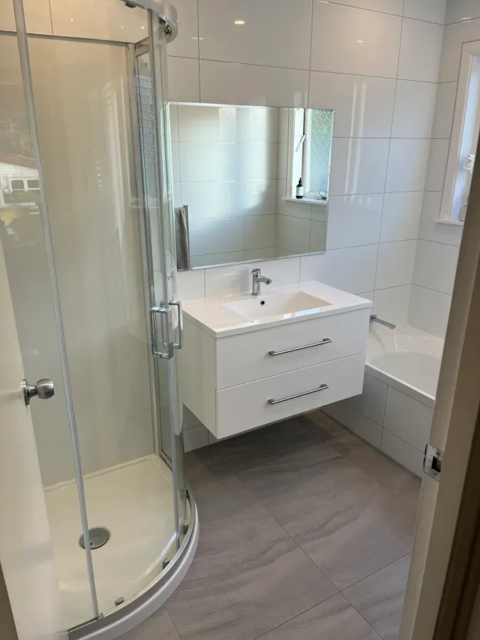 Completed bathroom with a timber double vanity and round mirrors